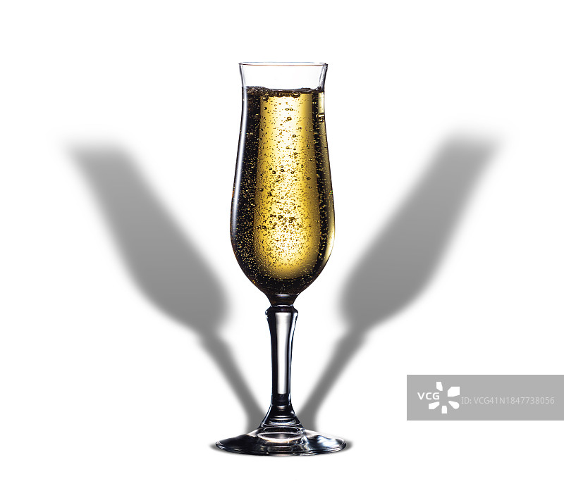 香槟酒杯在白色背景上的特写，有两个细长的小阴影。图片素材
