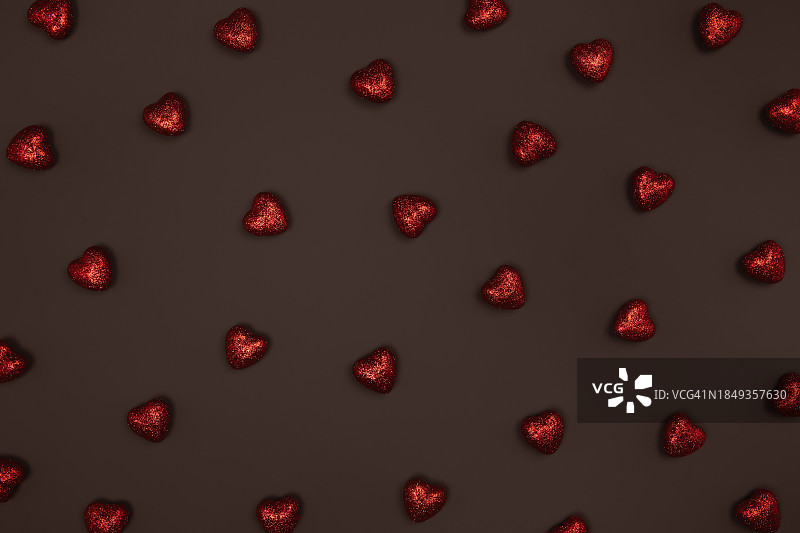 全帧图案的红色闪亮的心在黑巧克力的背景。平躺，俯视图。图片素材