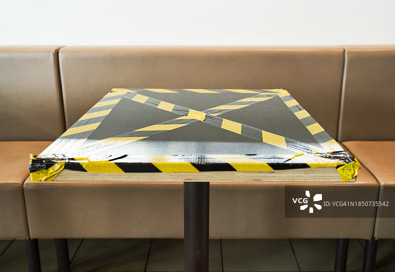 一张画有警告标志的桌子的正面，背景是一把扶手椅或沙发图片素材