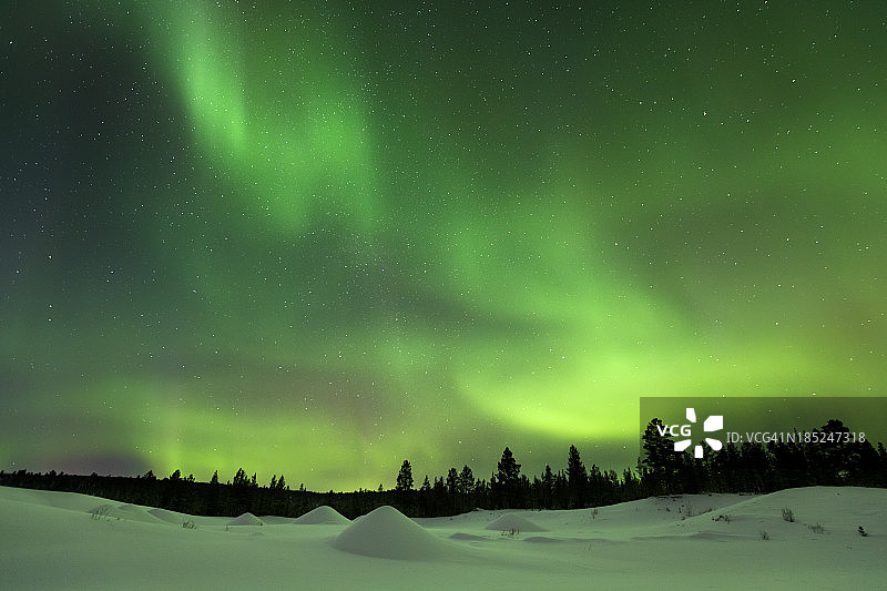 芬兰拉普兰，冬日雪地上的北极光图片素材