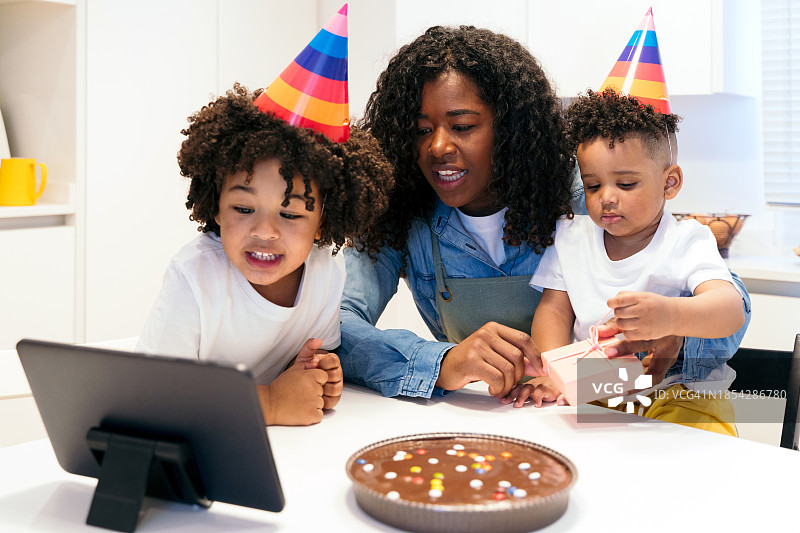 年轻的家庭庆祝孩子的生日的肖像连接在在线视频通话图片素材