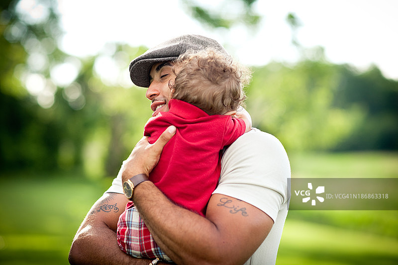 夏天站在外面快乐的父亲拥抱儿子图片素材
