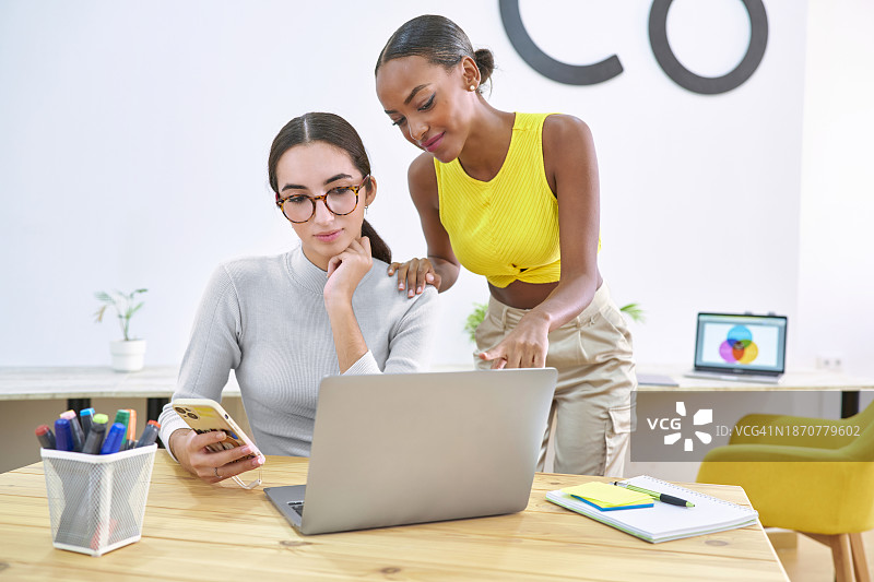 两个女孩在联合办公中心用电脑做电子商务生意图片素材