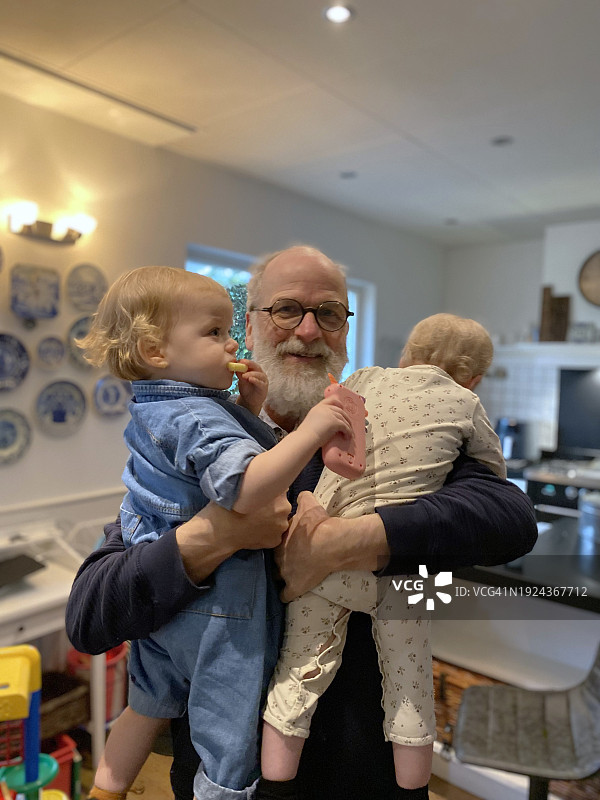 骄傲的爷爷抱着双胞胎宝宝图片素材