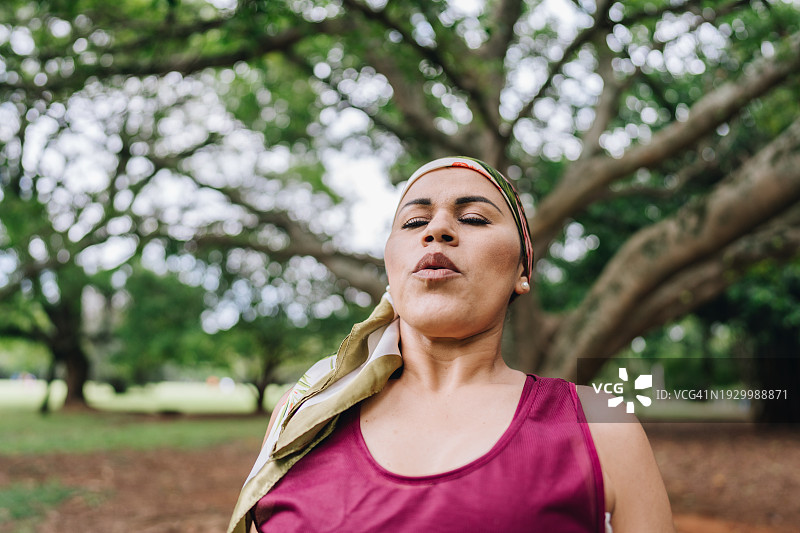 一位与癌症抗争的成熟女性在公园做呼吸练习图片素材