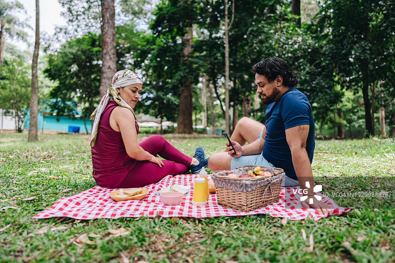 中年男子与妻子在公园野餐时拍照图片素材