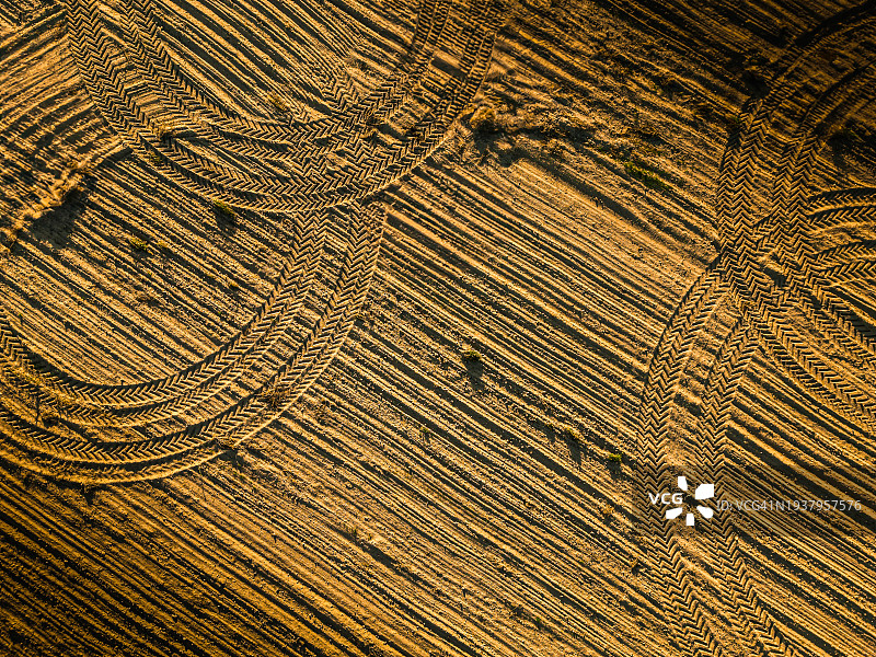 无人机拍摄的农田上农业机械车轮的痕迹。图片素材
