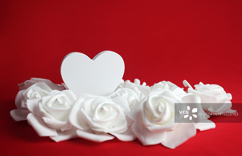 心形与白色玫瑰在红色的背景图片素材