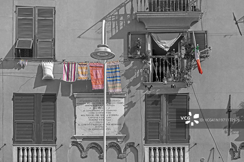 位于欧洲意大利热那亚历史城市中心的住宅建筑立面，绿色百叶窗和晾衣图片素材