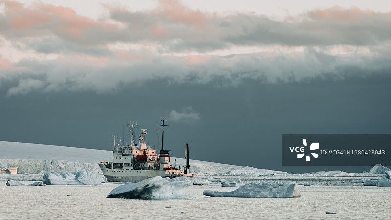 被冰山包围的南极半岛抛锚的破冰船图片素材