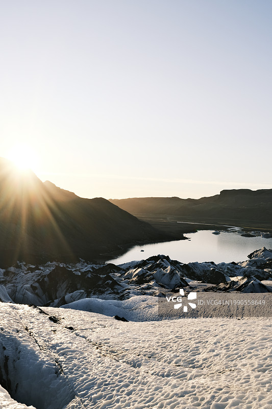 日落时分，白雪皑皑的群山映衬着晴朗的天空图片素材