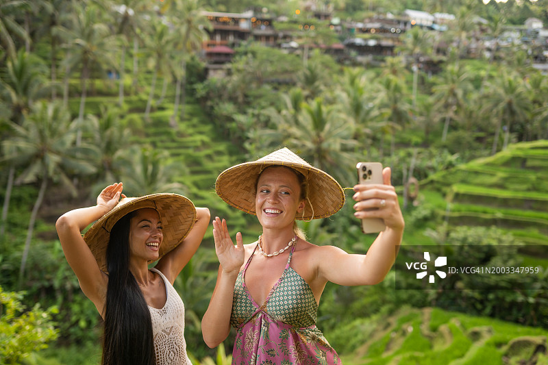 女性朋友在印度尼西亚巴厘岛美丽的tegalalang水稻梯田自拍图片素材