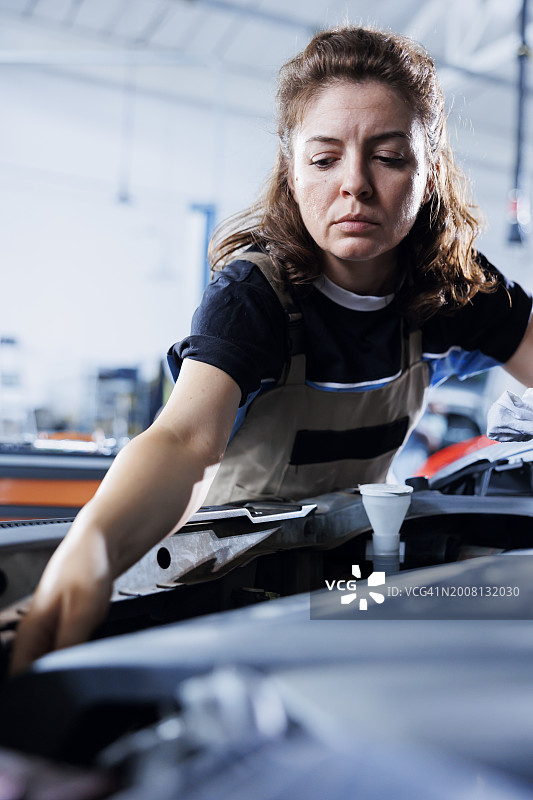 在汽车修理厂工作的女机械师图片素材