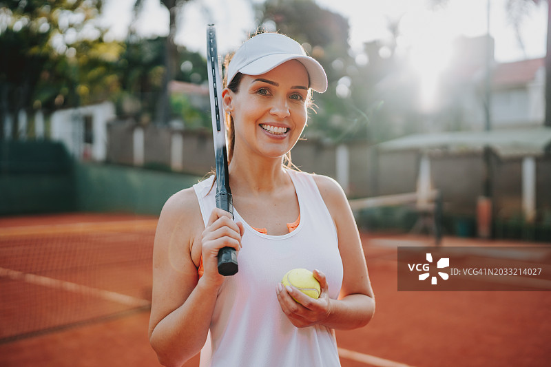 一个女人在网球场上拿着球拍的肖像图片素材
