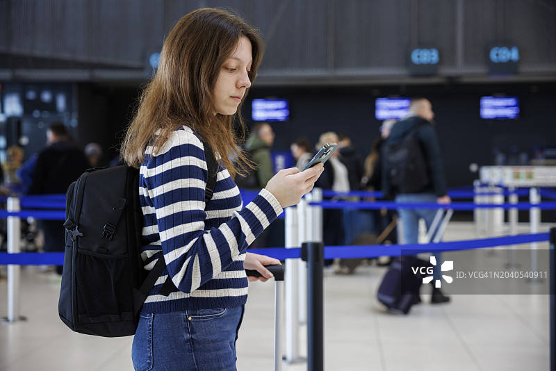 年轻女子在机场使用手机图片素材