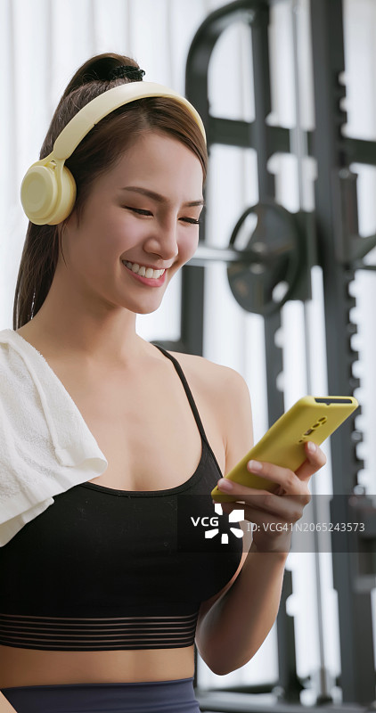 健身房的女性智能手机耳机图片素材