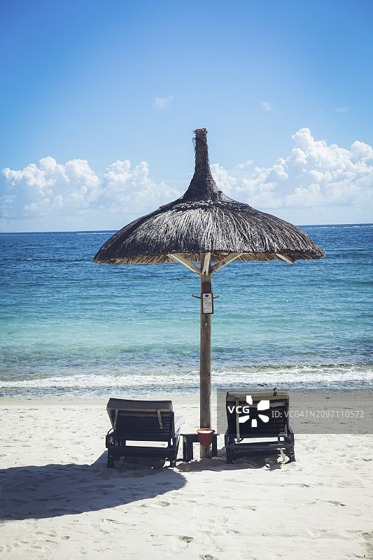 在沙滩上遮阳伞下晒太阳图片素材