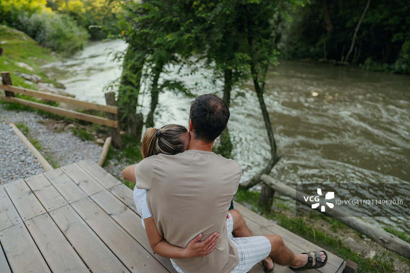 一对恩爱的夫妇坐在河边图片素材