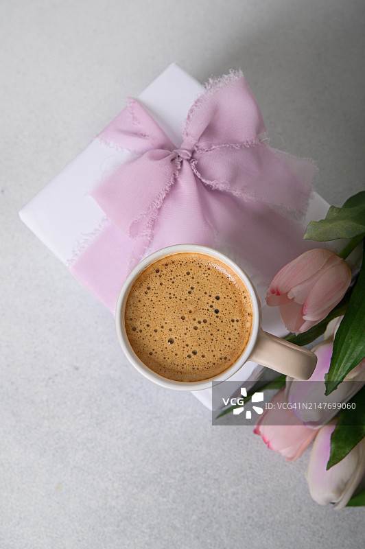 母亲节快乐，国际妇女节贺卡。给母亲的咖啡，带蝴蝶结和一束郁金香的礼物图片素材
