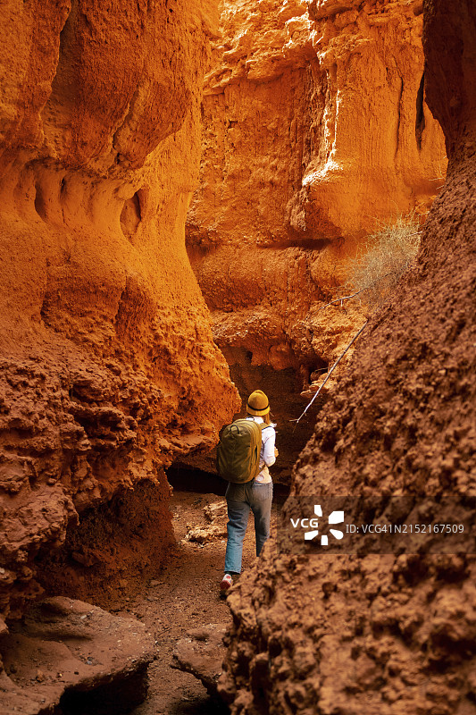 背着背包徒步穿过红色峡谷的女人图片素材