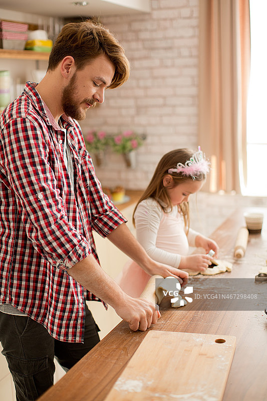 父亲和女儿在厨房烘焙。图片素材