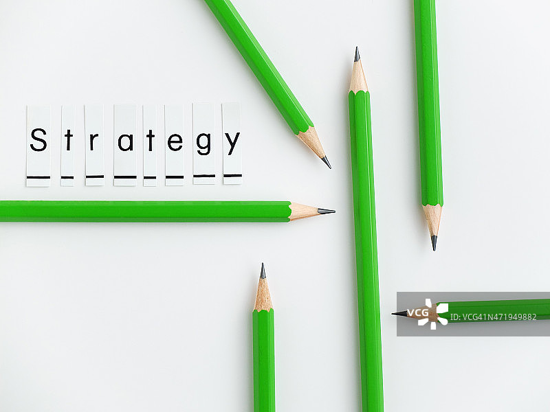 “策略”一词与彩色铅笔在白色的背景。图片素材