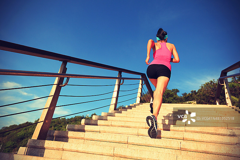 健康的生活方式运动女人跑上海边的石头楼梯图片素材
