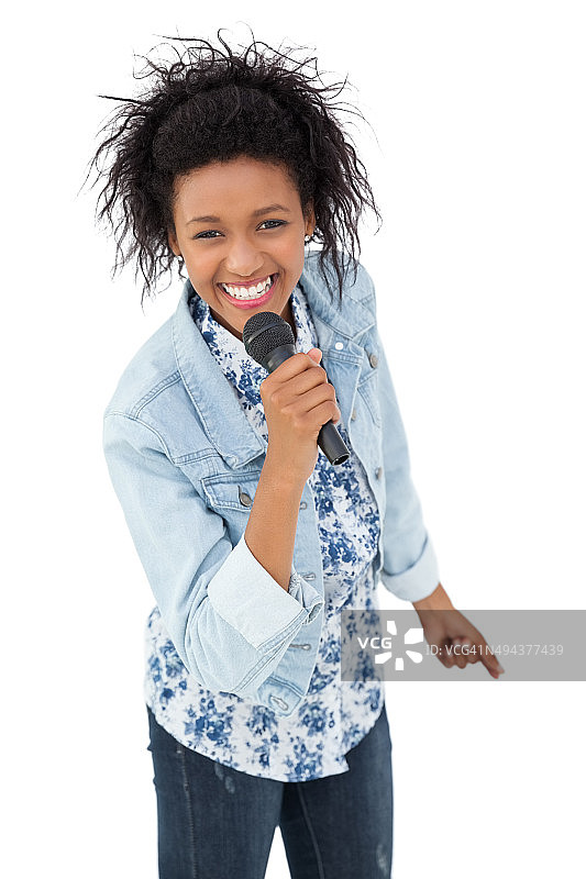 一个年轻女人对着麦克风唱歌的肖像图片素材
