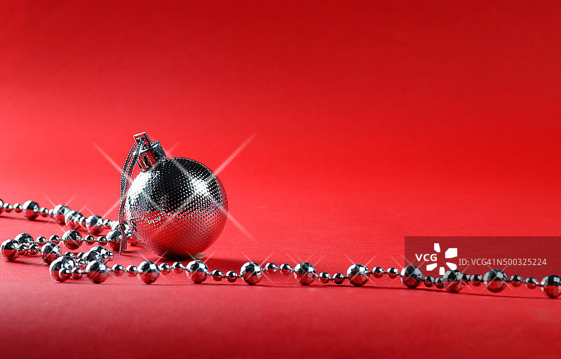 银色圣诞球与装饰品在红色的背景。图片素材