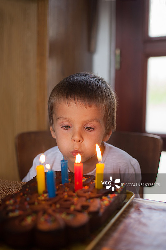 可爱的五岁男孩庆祝他的生日和吹图片素材