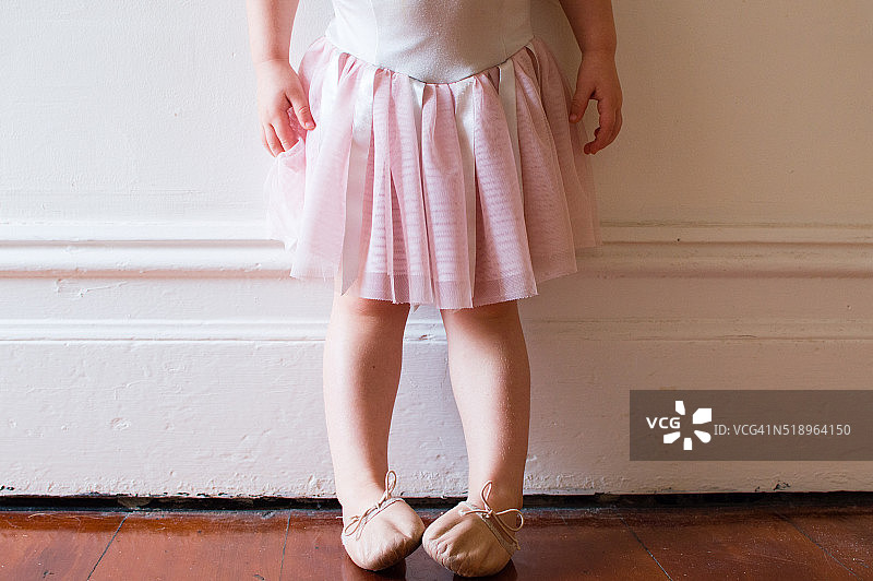 蹒跚学步的孩子穿着粉红色的芭蕾舞裙图片素材