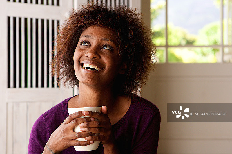 快乐的年轻女子，喝着咖啡图片素材