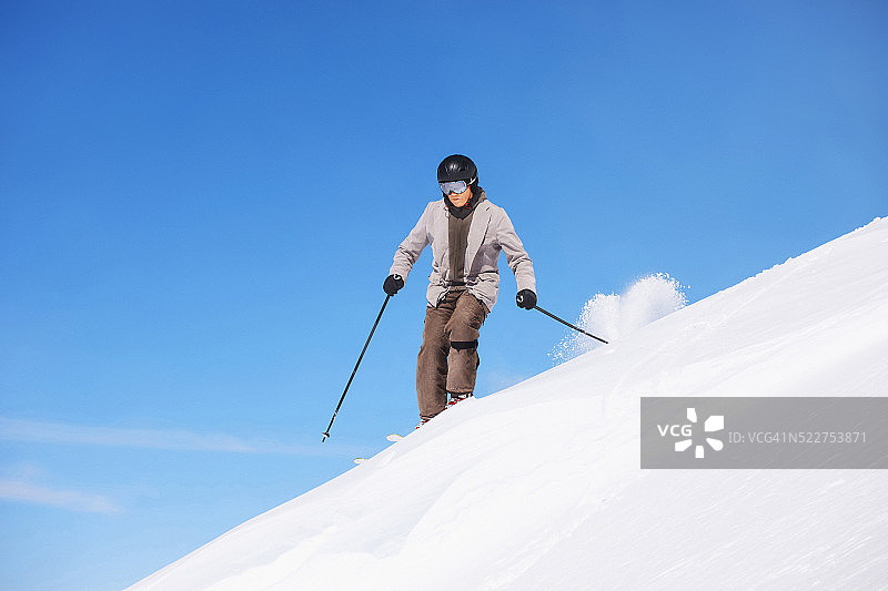 成熟的男人在雪道外滑雪粉雪阳光明媚的滑雪场图片素材