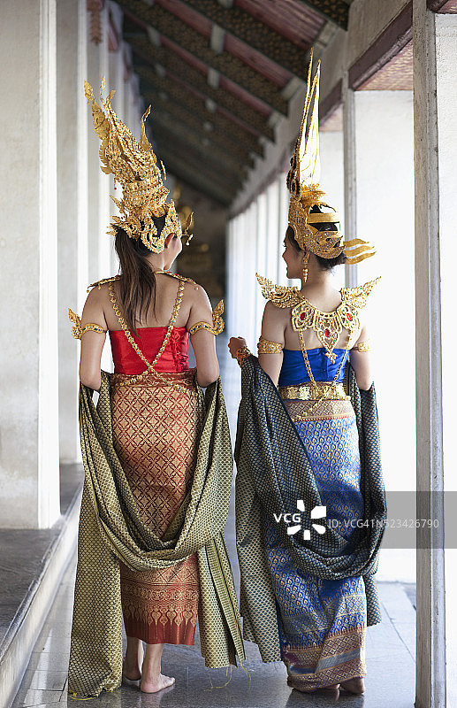 泰国曼谷，传统的泰国舞者在寺庙走道上聊天图片素材