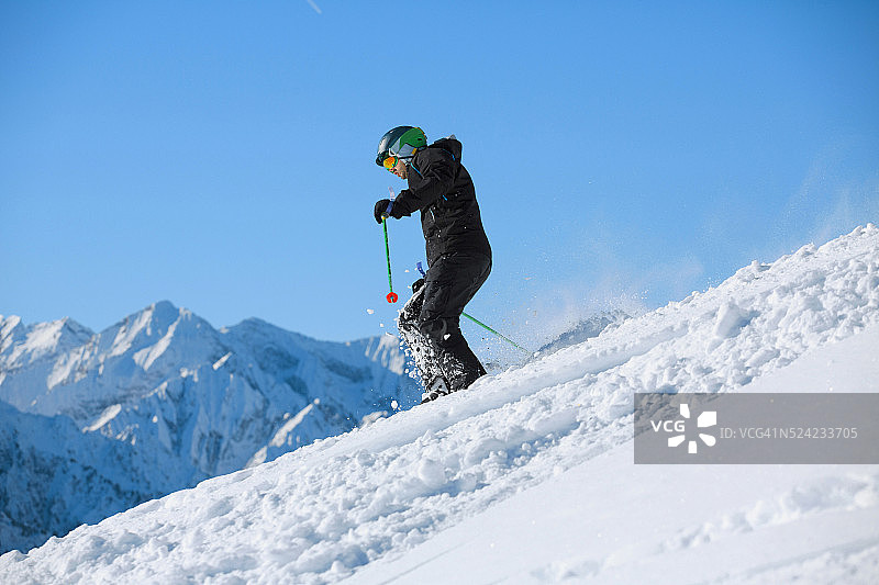 男子滑雪者离开雪道滑雪粉雪阳光明媚的滑雪胜地图片素材