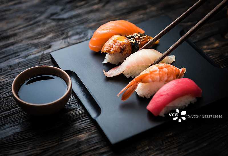 近距离的生鱼片寿司与筷子和酱油图片素材