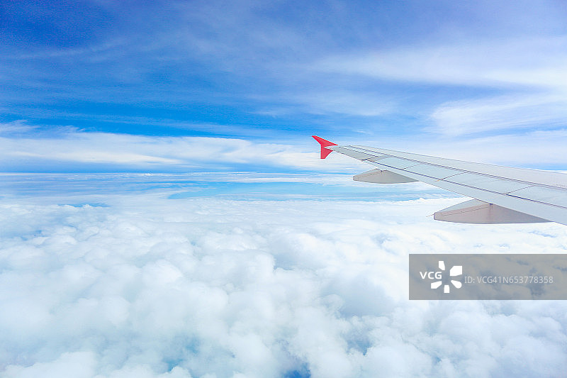 透过飞机窗户看到的云朵和天空。图片素材