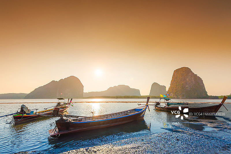 美丽的日落在热带海洋与长尾船在泰国南部图片素材