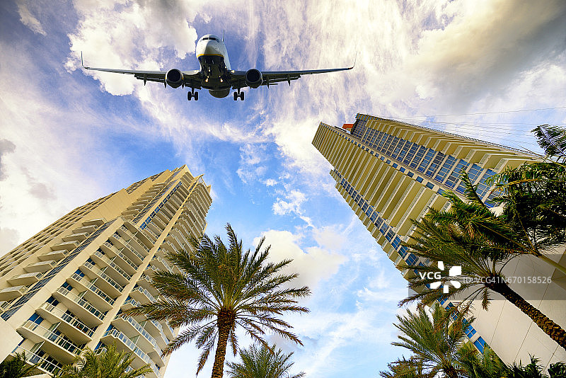 飞机飞过美国佛罗里达州迈阿密的建筑物图片素材