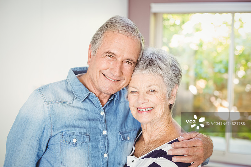 幸福的老年夫妇在家里拥抱的肖像图片素材