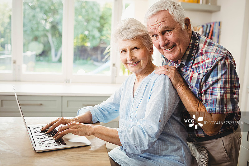 老年夫妇使用笔记本电脑的肖像图片素材