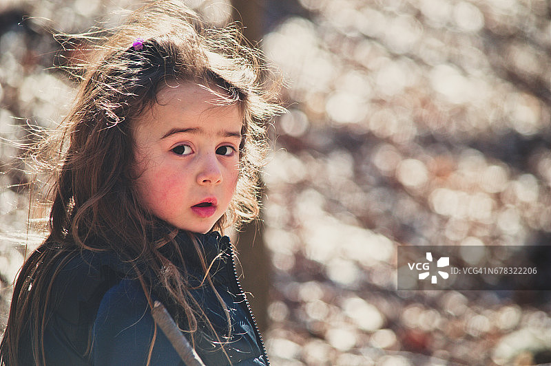 一个小女孩在树林里徒步旅行。图片素材