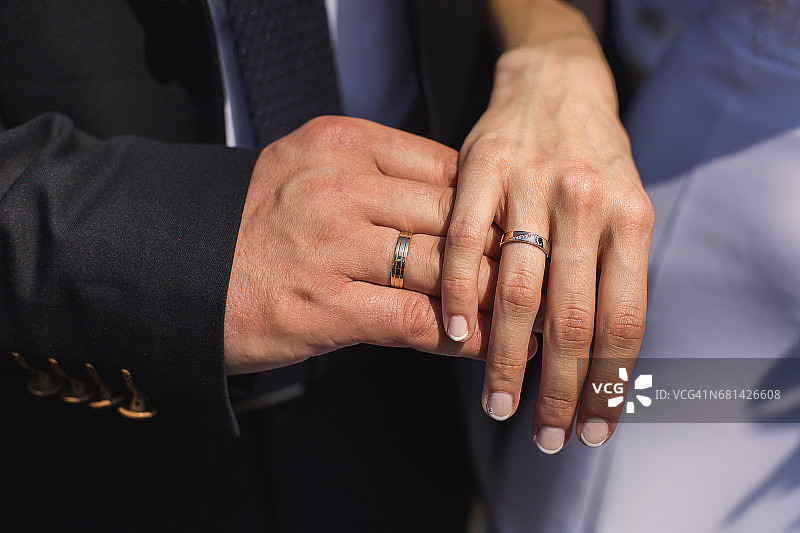 手上戴着结婚戒指，手指上戴着戒指的新娘和新郎都戴着戒指图片素材