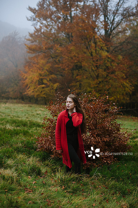 森林里穿红色大衣的女人的肖像图片素材