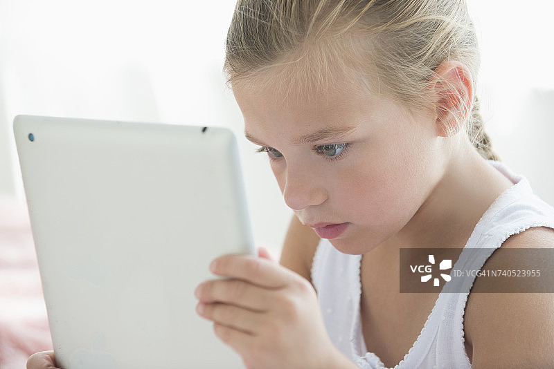 一个白人女孩在看平板电脑图片素材