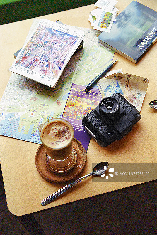 桌上有卡布奇诺，相机，地图和书在布宜诺斯艾利斯图片素材