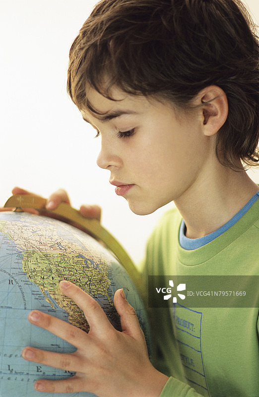 男孩(9-10岁)，带着地球仪，肖像图片素材