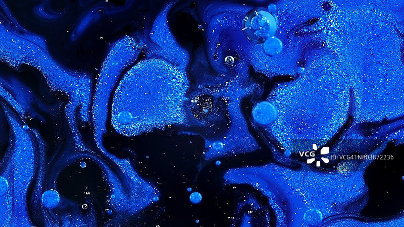 蓝色的火花和流动在黑色和紫色空空3活力明亮的油漆和油颜色旋涡熵图片素材