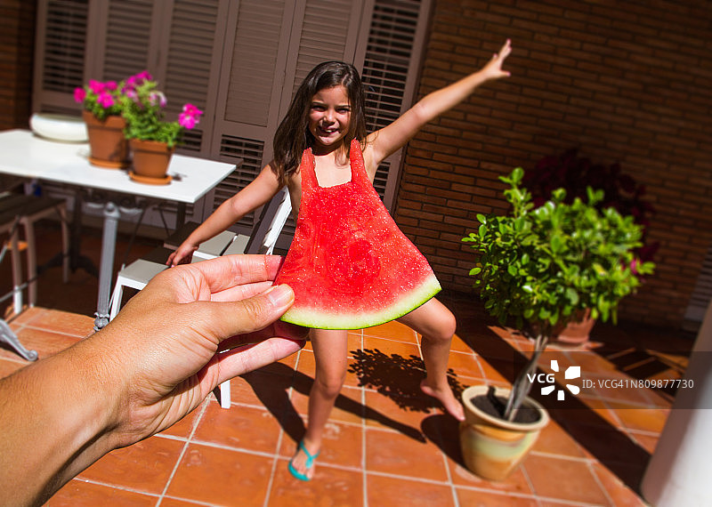 这是一张有趣的西瓜裙挑战图片，从个人角度拍摄，适合一个小女孩的西瓜大小，玩透视法。图片素材