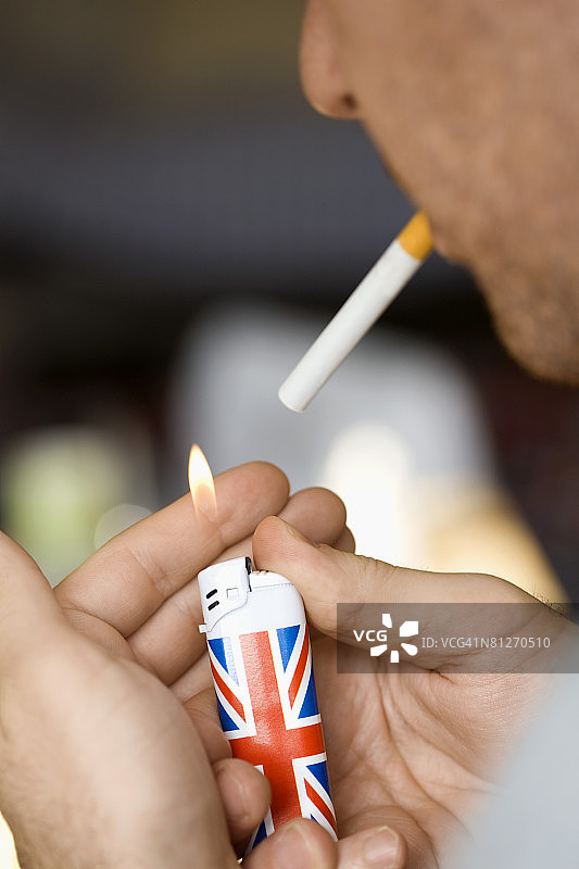 男子用英国国旗打火机点烟图片素材